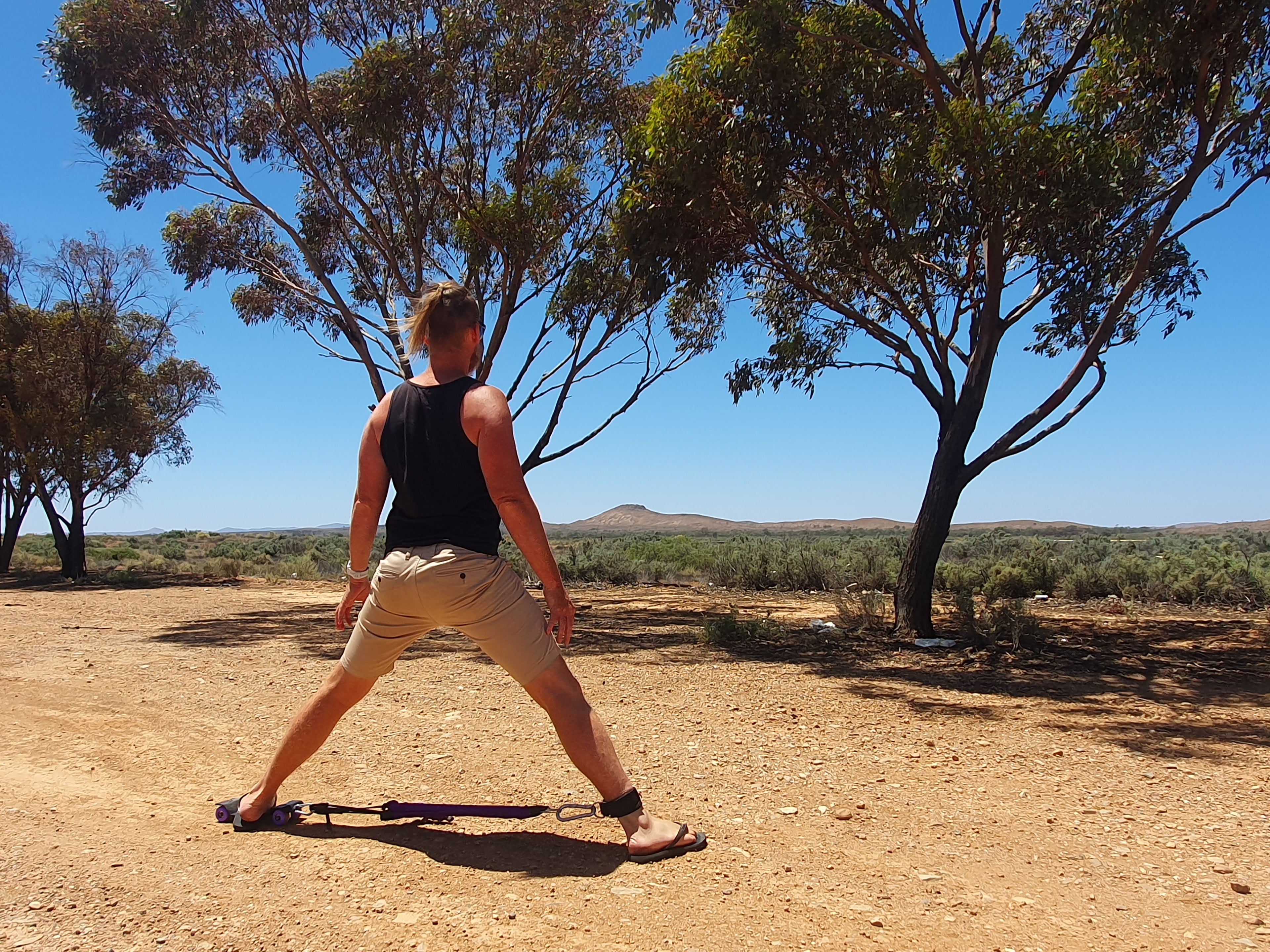 Man Using Strexi for Middle Split in Desert